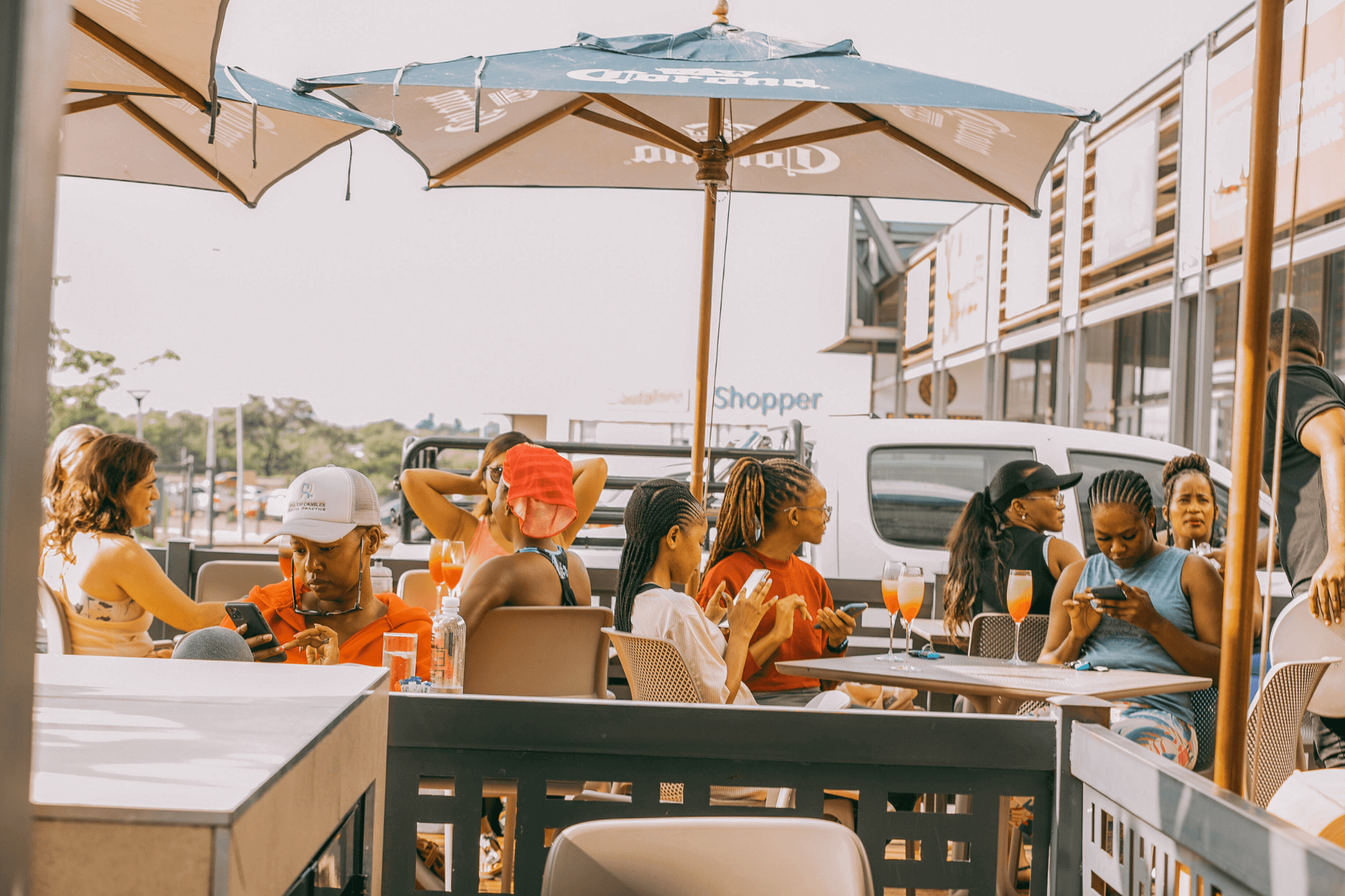 Group of women seated outdoors enjoying drinks and conversation after a yoga brunch event.